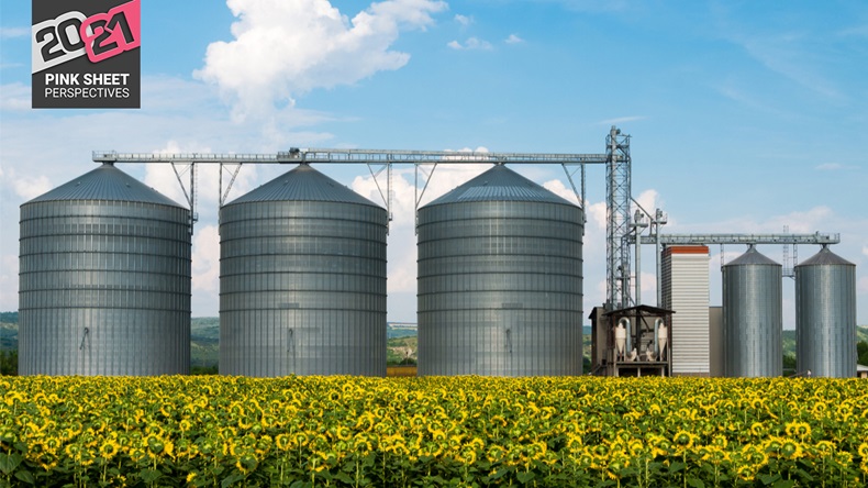 Silos. Warehouse storage of the harvest. Field with sunflowers.