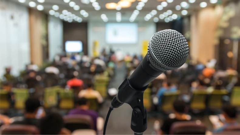 Microphone over the Abstract blurred photo of conference hall or seminar room with attendee background - Image 