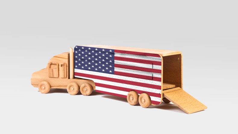 Close-up of a wooden toy truck with a painted national flag USA. The concept of export-import,transportation, national delivery of goods 