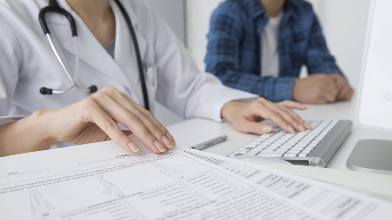 Doctor to explain to the patient while checking documents and computer