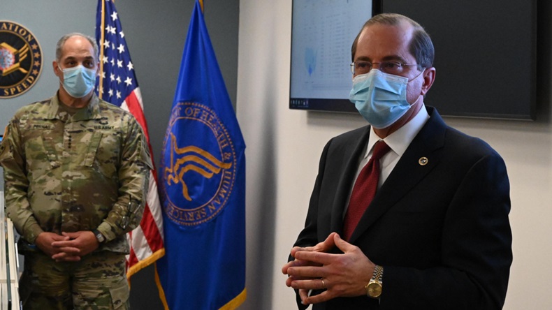 HHS Secretary Alex Azar and General Gus Perna visit the Vaccine Operation Center in HHS's Hubert H. Humphrey building, where Operation Warp Speed is monitoring the progress of the distribution effort. On the screen behind them, Texas has turned blue. (Photo: HHS))