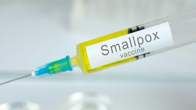 Vaccination healthcare concept. Hands of doctor or nurse in medical gloves with medical syringe ready for injection a shot of Smallpox vaccine.