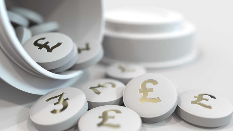 Close-up shot of pills with stamped pound sterling GBP symbol on them. 