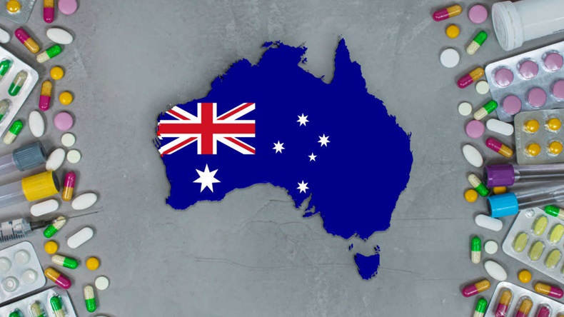 Medicine, pills, needles, syringes and Australia map and flag on gray background.