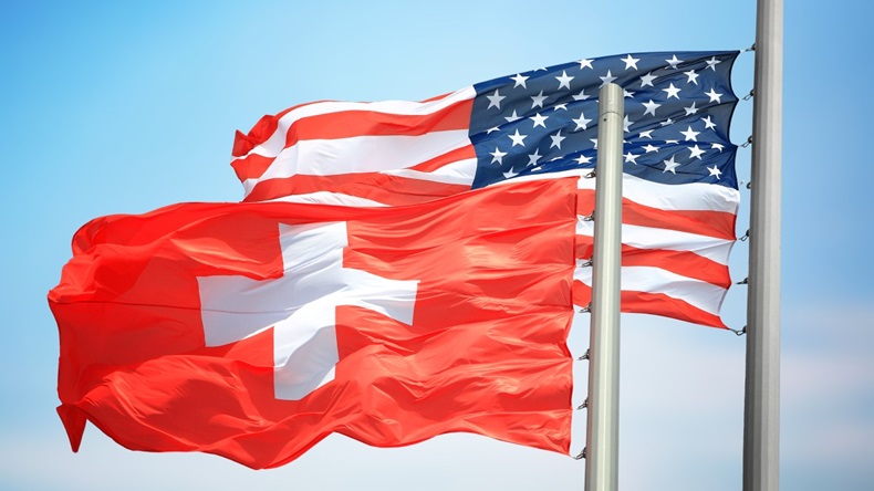 Flags of Switzerland and the USA against the background of the blue sky