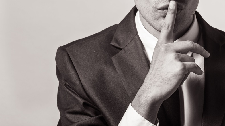 close up of person in business shoot going "shh" with finger 