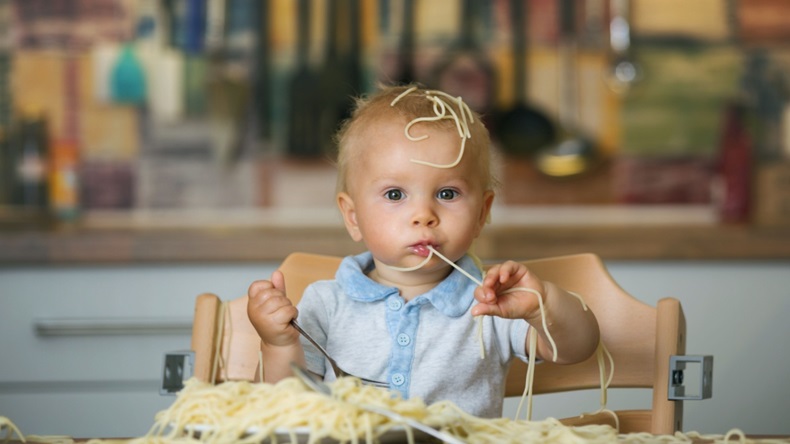toddler making a mess eating spaghetti 