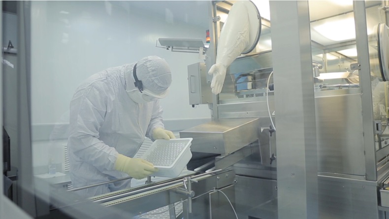 Pharmaceutical industry. Male factory worker inspecting quality of pills packaging in pharmaceutical factory. Automatic tape to create packaging and filling of medicines. control in the factory of