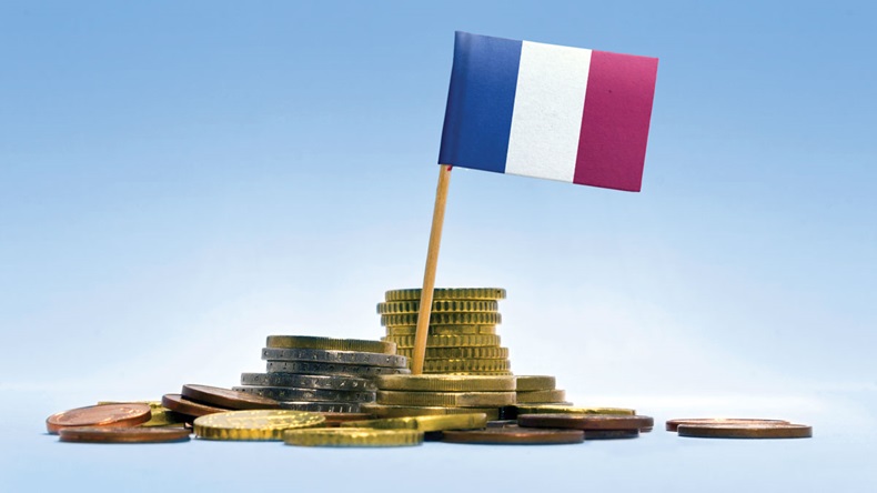 Flag of France in a mixed stack of european coins and a blue background
