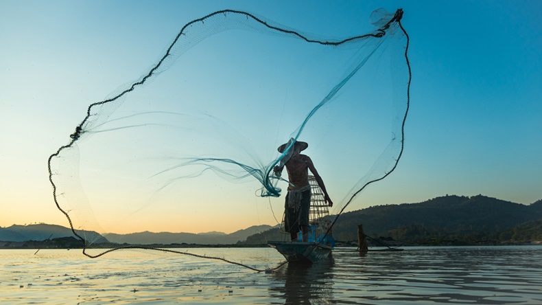 Fisherman casting his net at the sunset at Mae Klong River, Thailand